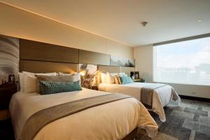 a hotel room with two beds and a large window at EK Hotel By Preferred Hotels Group in Bogotá +63 photos