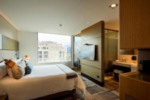 a hotel room with a bed and a large window at EK Hotel By Preferred Hotels Group in Bogotá