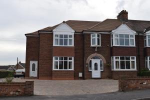 uma casa de tijolos com portas e janelas brancas em Barton Guest House em Barton upon Humber