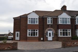 a brick house with white doors and windows at Barton Guest House in Barton-upon-Humber