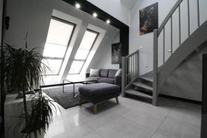 a living room with a chair and a stair case at Bulwar Apartament in Głogów