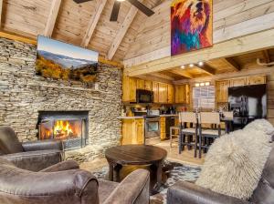 a living room with a stone fireplace in a cabin at Ole Red in Gatlinburg