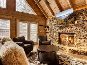 a living room with a stone fireplace in a cabin at Ole Red in Gatlinburg