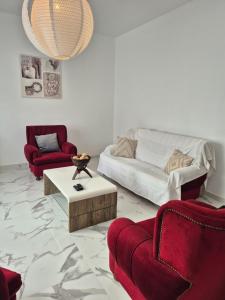 a living room with red chairs and a couch at Villa Vista Norte in Porto Moniz