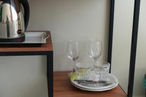 a table with three glasses and a plate on it at Pousada Vasconcelos Tianguá in Tianguá