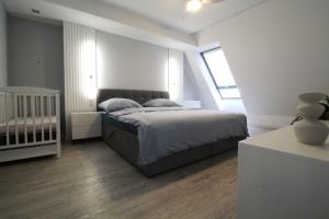 a bedroom with a bed and a crib in it at Bulwar Apartament in Głogów