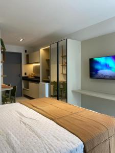 a bedroom with a large bed with a tv on the wall at FLAT Intermares HUB 105 in Cabedelo