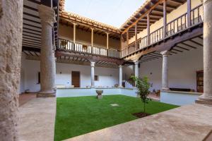 a courtyard in an old building with a plant at La Casa de la botica -Casa Rural El Romeral de Toledo in Romeral