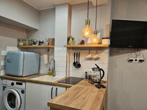 a kitchen with a counter with a sink and a refrigerator at Studio apartment in Rēzekne