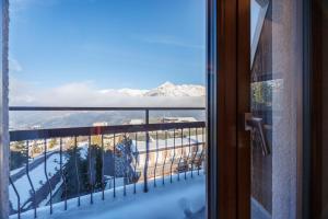 a view of a snowy mountain from a window at Lift Hotel in Sauze dʼOulx