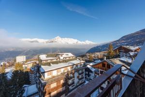 a view from the balcony of a hotel with snow covered mountains at Lift Hotel in Sauze dʼOulx