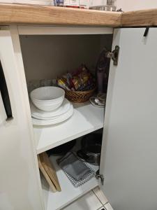 a cupboard with a bowl and plates in it at Studio apartment in Rēzekne