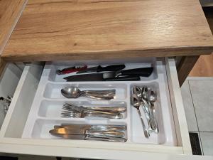 a drawer with silver utensils in a cabinet at Studio apartment in Rēzekne