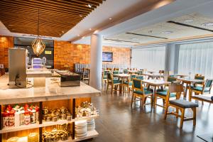 a restaurant with tables and chairs and a counter at Hotel Le Pelican in Asunción