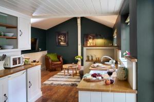 a kitchen and living room with green walls at Courtyard Cottages Lymington, 2 Adults only in Lymington
