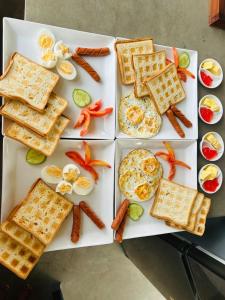 a plate of food with waffles and eggs and carrots at Ayathma Heights in Weligama