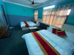 a hotel room with two beds and a window at Parbat unique guest house in Kathmandu