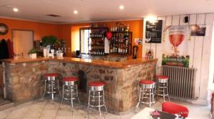 a bar with red stools in a restaurant at Gite d'étape le code bar in Saint-Julien-Labrousse