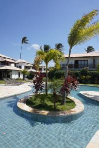 a swimming pool with palm trees in a resort at Condomínio Villa Conduru - Casa completa in Prea