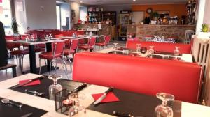 a restaurant with red chairs and tables in a room at Gite d'étape le code bar in Saint-Julien-Labrousse