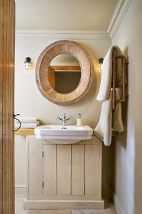 a bathroom with a sink and a mirror at Courtyard Cottages Lymington, 2 Adults only in Lymington