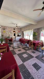 a restaurant with red tables and chairs in a room at Hotel Maresias in Villa Gesell