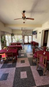 a room with tables and chairs and a ceiling fan at Hotel Maresias in Villa Gesell +18 photos