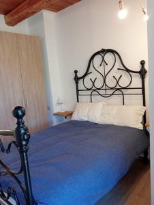 a bedroom with a black bed with a blue blanket at Rifugio Combe D'Imbert Vittoria in Champ Quartier