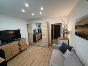 a living room with a couch and a flat screen tv at SECRETO Apartman 1 in Komárno +1 photo