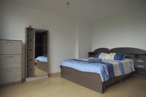 a bedroom with a bed and a dresser and a mirror at Casa Calma in Quito
