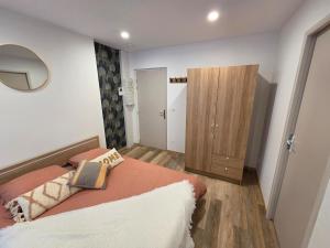 a bedroom with a bed and a wooden cabinet at Le Sebastopol- Studio cosy en centre ville de Brioude in Brioude