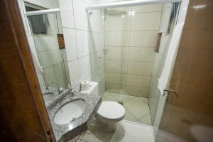a small bathroom with a toilet and a shower at Vila Dumont no Centro de Foz in Foz do Iguaçu