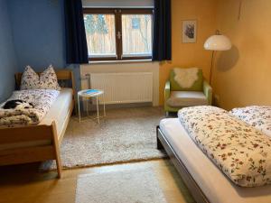 a bedroom with two beds and a chair and a window at Baers Mountain Stay Außerbraz in Innerbraz
