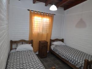 two beds sitting in a room with a window at Mercedario Aparts in Barreal