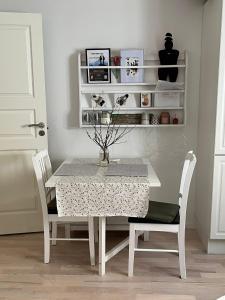 a dining room table with a white table and chairs at Qaqortoq Spa Accommodation in Qaqortoq