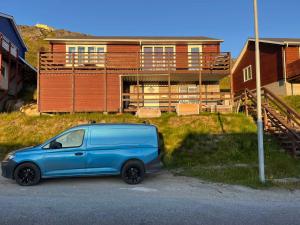 a blue van parked in front of a house at Qaqortoq Spa Accommodation in Qaqortoq +11 photos