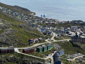 an aerial view of a town on a hill next to the ocean at Qaqortoq Spa Accommodation in Qaqortoq