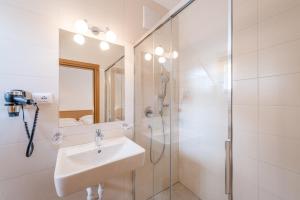 a white bathroom with a sink and a shower at Vogelmaierhof am Kalterer See in Caldaro +86 photos