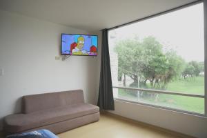 a living room with a couch and a large window at Casa Calma in Quito