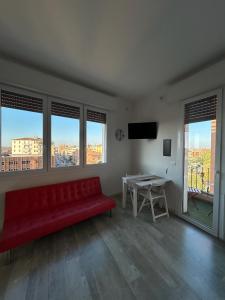 a living room with a red couch and a table at Stayinbologna 3 in Bologna