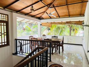 a dining room with a table and chairs on a balcony at Pearl Bungalow Trincomalee in Trincomalee