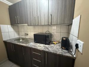 a kitchen with a counter top with a microwave at Tshiamo Estate in Kuruman