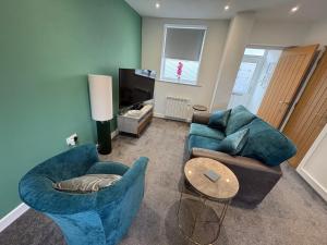 a living room with two blue chairs and a table at Cleveleys Town Centre in Blackpool