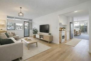 a living room with a couch and a tv at Modern 2BR Apartment North Adelaide in North Adelaide