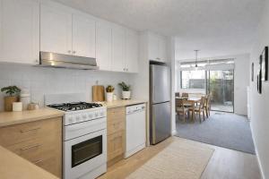 a kitchen with white appliances and a dining room at Modern 2BR Apartment North Adelaide in North Adelaide