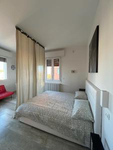 a bedroom with a large bed and a red couch at Stayinbologna 3 in Bologna
