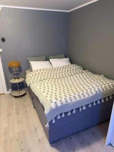 a bedroom with a bed with a blue bed frame at Hammergaarden - Kårstua - Panoramic Arctic Stay in Sortland