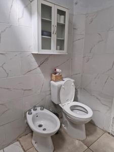 a white bathroom with a toilet and a sink at Alojamiento La Liboria, solo mujeres in Córdoba +11 photos
