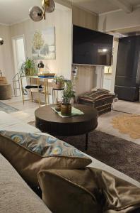 a living room with a couch and a tv at Hammergaarden - Kårstua - Panoramic Arctic Stay in Sortland
