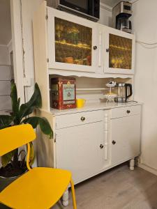 a white cabinet in a kitchen with a yellow table at Hammergaarden - Kårstua - Panoramic Arctic Stay in Sortland